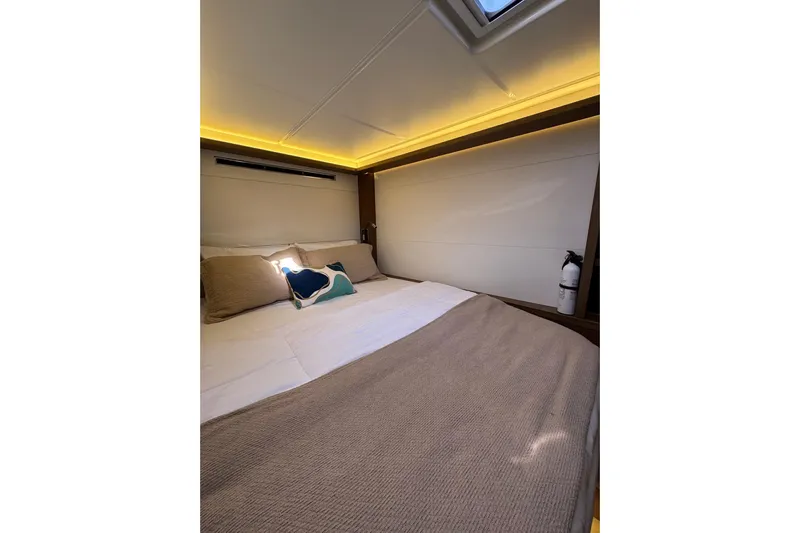  Yacht Photos Pics Luxurious cabin interior of 2020 Lagoon 46 yacht with cozy bedding and ambient lighting.