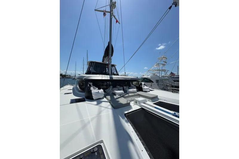  Yacht Photos Pics 2020 Lagoon 46 catamaran with spacious deck and seating, docked at marina.