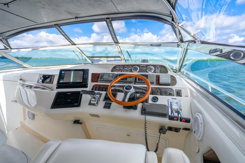 Knot Ez II Yacht Photos Pics Cockpit of 1998 Sea Ray 450 Sundancer yacht with wooden steering wheel and navigation instruments.