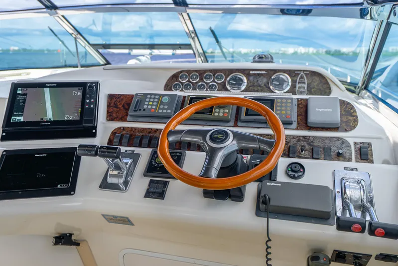 Knot Ez II Yacht Photos Pics Cockpit of 1998 Sea Ray 450 Sundancer with navigation instruments and wooden steering wheel.
