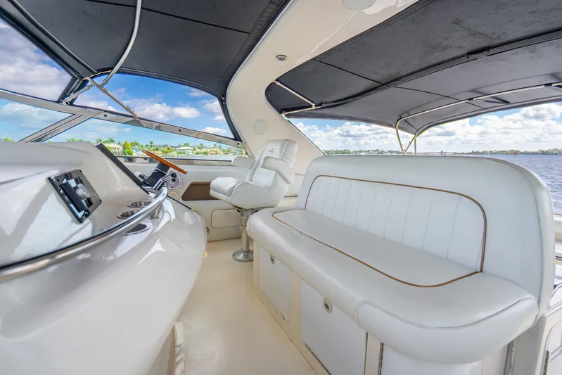 Knot Ez II Yacht Photos Pics 1998 Sea Ray 450 Sundancer yacht interior with white seating and helm, overlooking water.