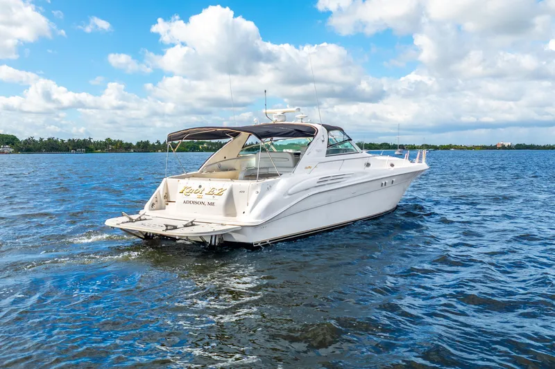 Knot Ez II Yacht Photos Pics 1998 Sea Ray 450 Sundancer yacht cruising on a sunny day with blue skies.