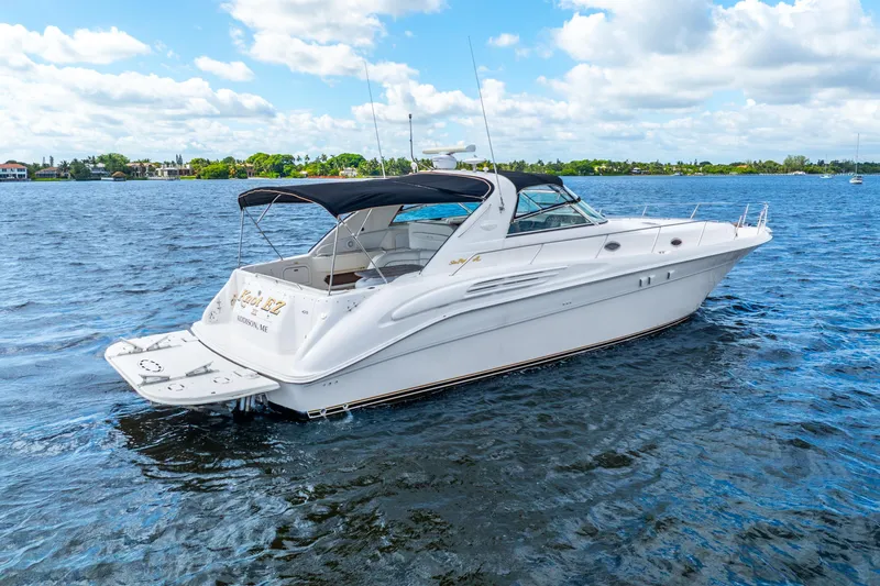 Knot Ez II Yacht Photos Pics 1998 Sea Ray 450 Sundancer yacht on calm blue waters under a partly cloudy sky.