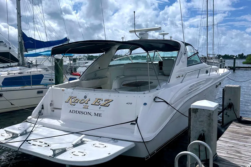 Knot Ez II Yacht Photos Pics 1998 Searay SUNDANCER 450 yacht docked at marina under cloudy sky.