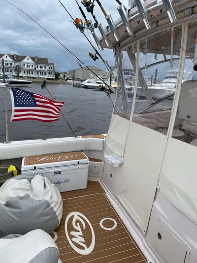  Yacht Photos Pics 2007 Grady-White Express 330 boat with fishing rods, American flag, and marina backdrop.