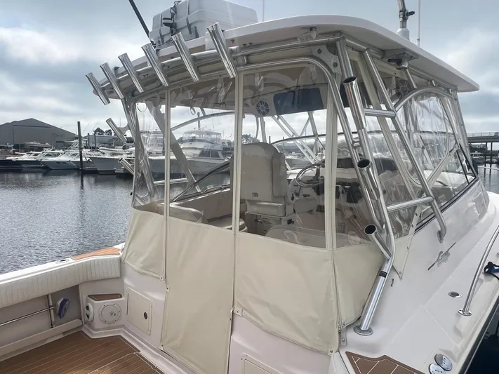  Yacht Photos Pics 2007 Grady-White Express 330 boat docked at marina, featuring enclosed cockpit and fishing rod holders.