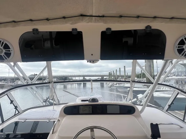  Yacht Photos Pics 2007 Grady-White Express 330 boat helm with marina view, featuring modern controls and speakers.