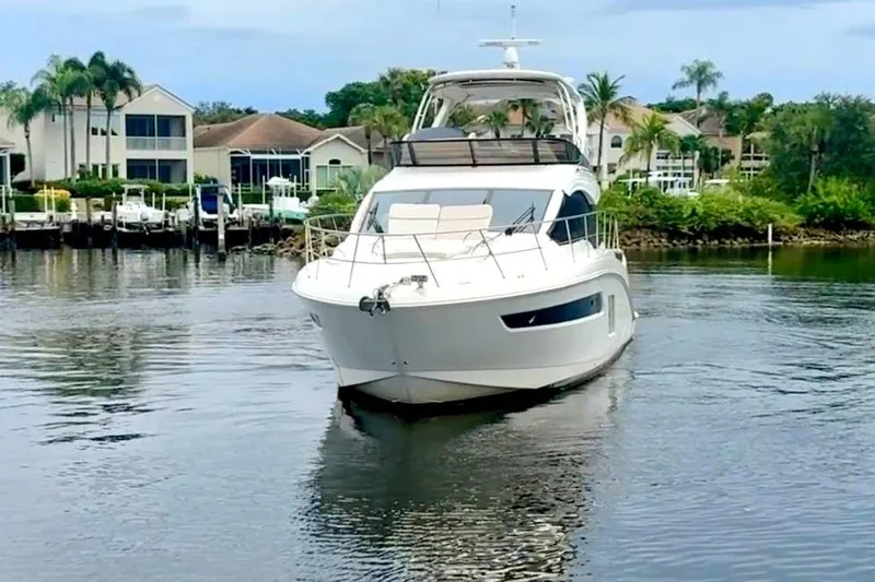 Caroline Kai Yacht Photos Pics 2016 Sea Ray 510 Fly yacht on calm water near waterfront homes.