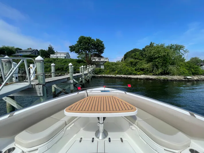  Yacht Photos Pics 2017 Boston Whaler 420 Outrage boat docked, featuring a wooden table and scenic waterfront view.