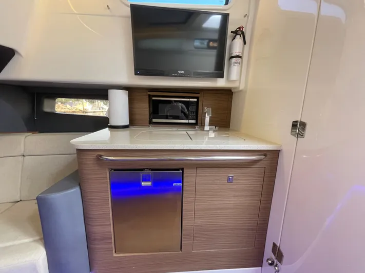 Yacht Photos Pics Interior of 2017 Boston Whaler 420 Outrage featuring kitchenette with TV, microwave, and fridge.