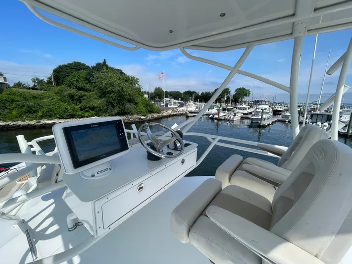  Yacht Photos Pics 2017 Boston Whaler 420 Outrage helm with dual seats, overlooking marina and lush greenery.