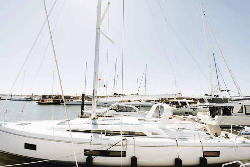  Yacht Photos Pics 2024 Beneteau Oceanis 51.1 sailboat docked in a sunny marina.