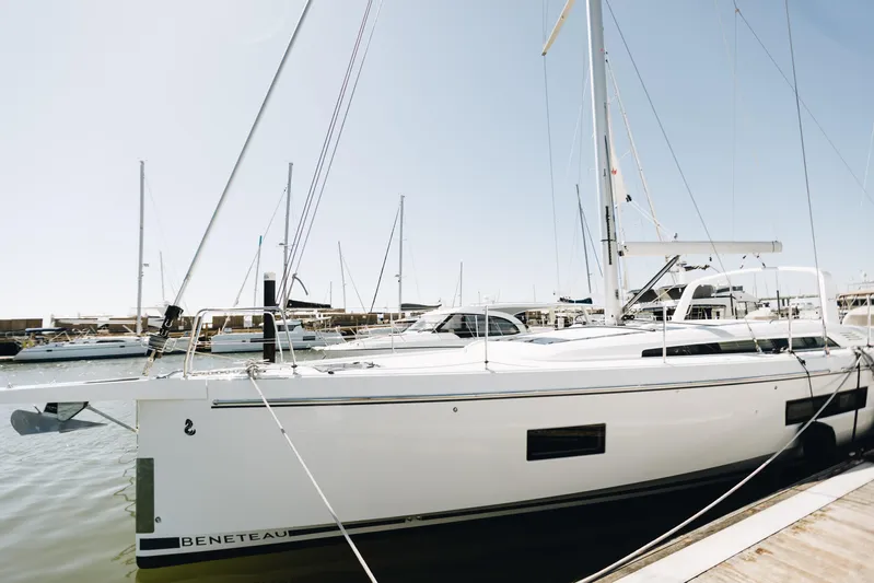  Yacht Photos Pics 2024 Beneteau Oceanis 51.1 yacht docked in a marina under clear skies.
