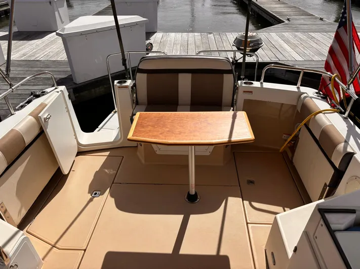 Seahorse Yacht Photos Pics 2016 Cutwater 28 LE boat interior with seating and wooden table, docked at marina.