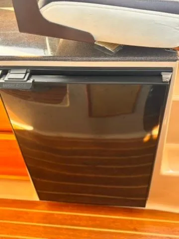 Seahorse Yacht Photos Pics 2016 Cutwater 28 LE interior with sleek black refrigerator and wooden flooring.