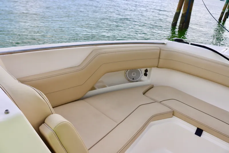  Yacht Photos Pics 2017 Pursuit DC 295 Dual Console boat interior with beige seating by the water.