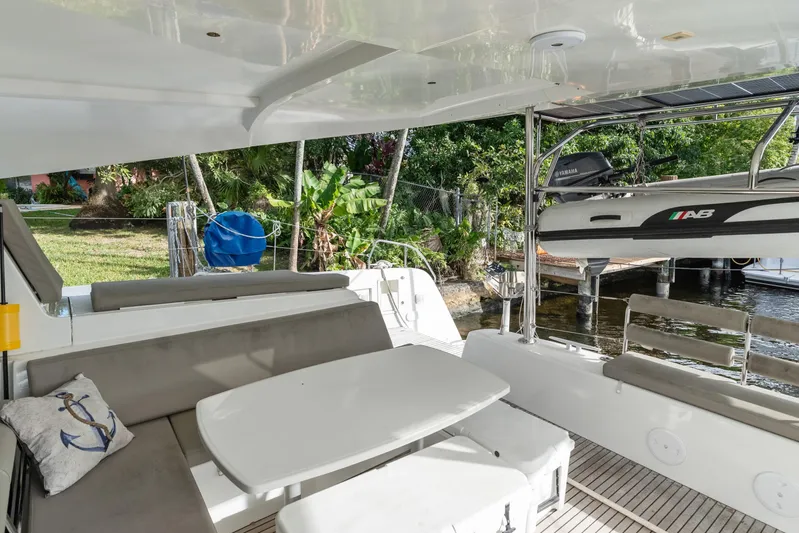 Benedetto Yacht Photos Pics Outdoor seating area on a 2020 Lagoon 42 catamaran, featuring a table and lush surroundings.