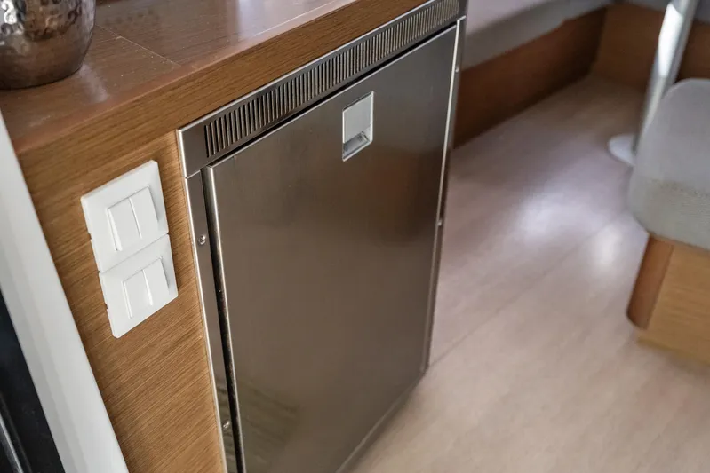 Benedetto Yacht Photos Pics Interior of 2020 Lagoon 42 yacht featuring a stainless steel fridge and wooden cabinetry.