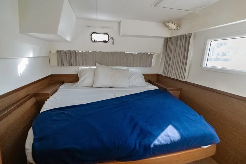 Benedetto Yacht Photos Pics Cozy cabin interior of 2020 Lagoon 42 catamaran with bed and porthole window.