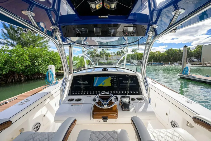 Fishability Yacht Photos Pics 2025 Valhalla Boatworks V-41 helm with advanced navigation system, docked by lush greenery.