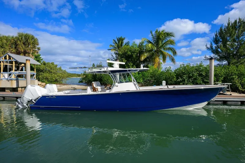 Fishability Yacht Photos Pics 2025 Valhalla Boatworks V-41 in marina, blue hull, tropical backdrop, clear sky.