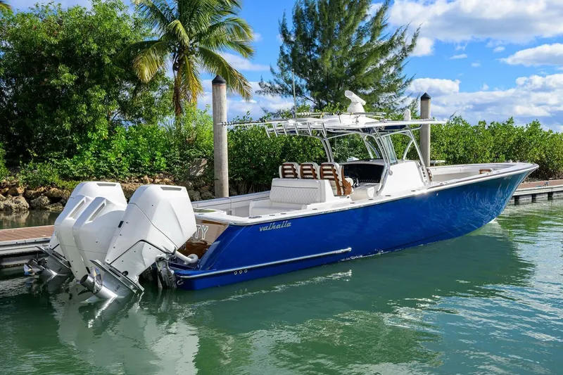 Fishability Yacht Photos Pics 2025 Valhalla Boatworks V-41 in blue, docked by lush greenery and clear skies.