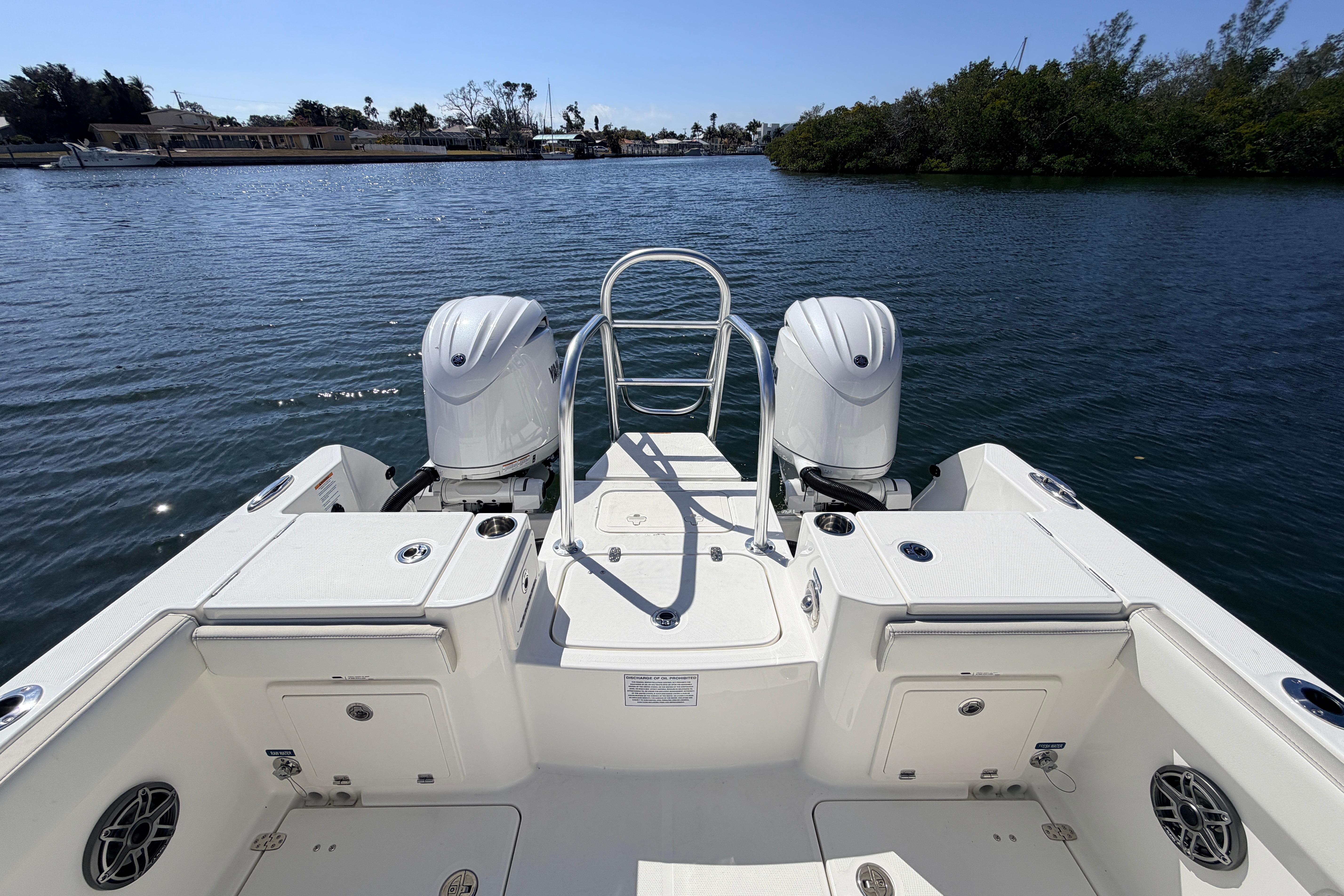 2026 World Cat 235 TE boat with dual engines on a serene waterway.