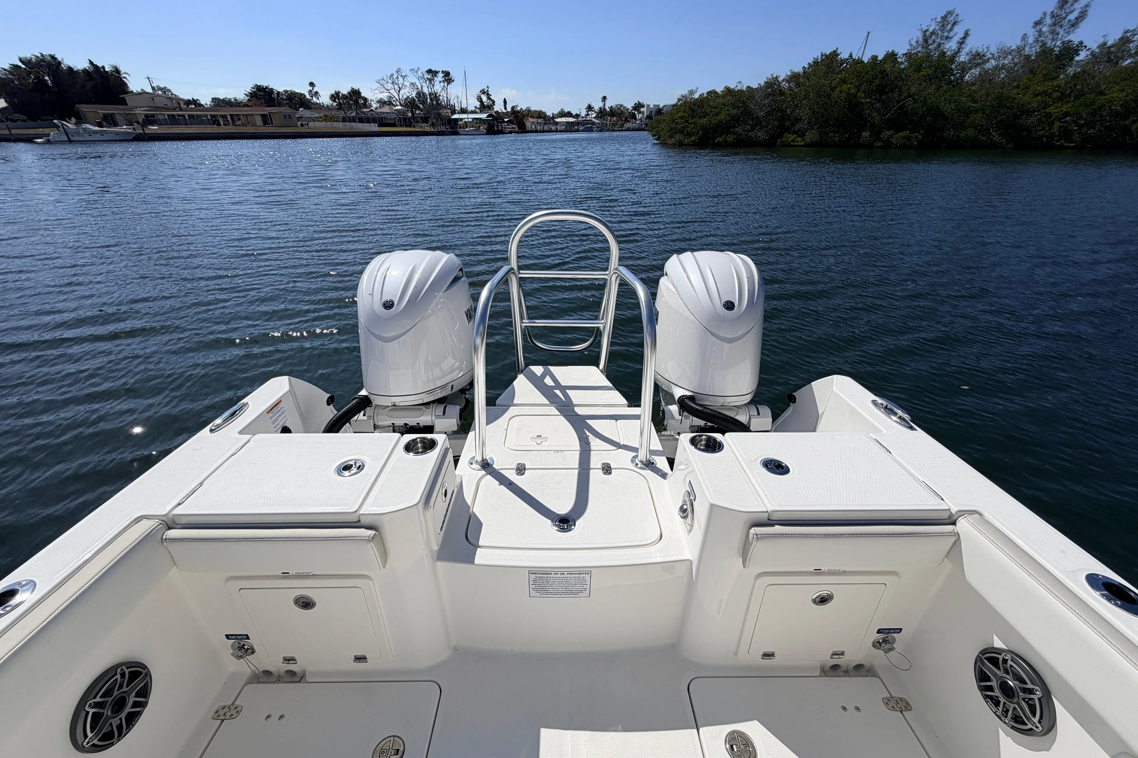 2026 World Cat 235 TE boat with dual engines on a serene waterway.