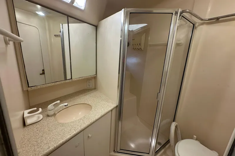  Yacht Photos Pics 1999 Silverton 442 Cockpit Motor Yacht bathroom with shower, sink, and mirror.