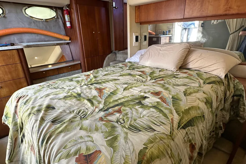  Yacht Photos Pics 1999 Silverton 442 Cockpit Motor Yacht bedroom with tropical bedding and wooden cabinetry.
