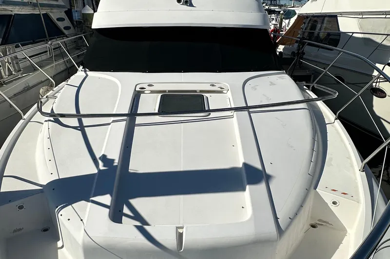  Yacht Photos Pics 1999 Silverton 442 Cockpit Motor Yacht, white deck view, docked between boats.