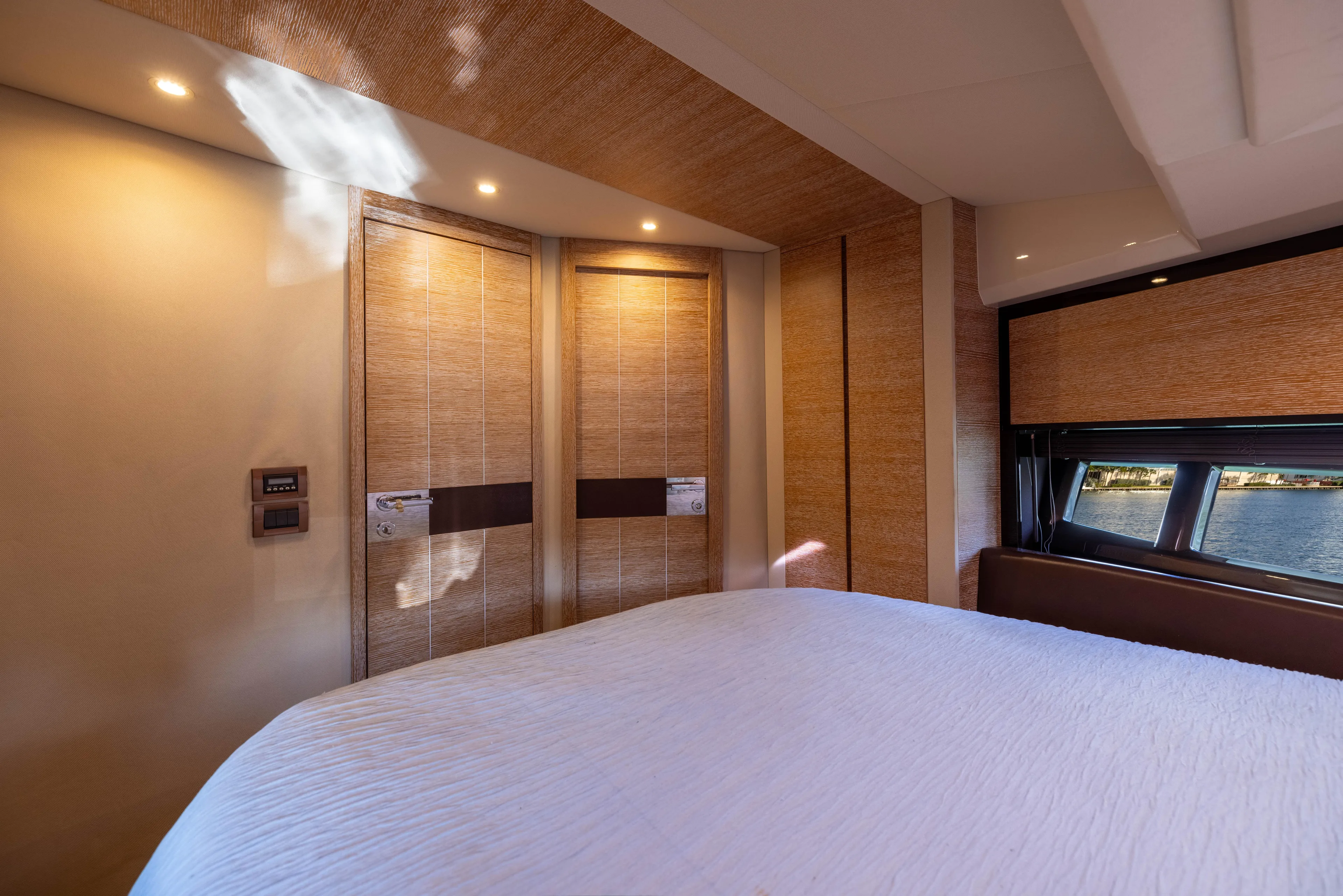 Blue Sea Yacht Photos Pics Luxurious bedroom interior of 2012 Azimut 53 yacht with elegant wood paneling and window view.