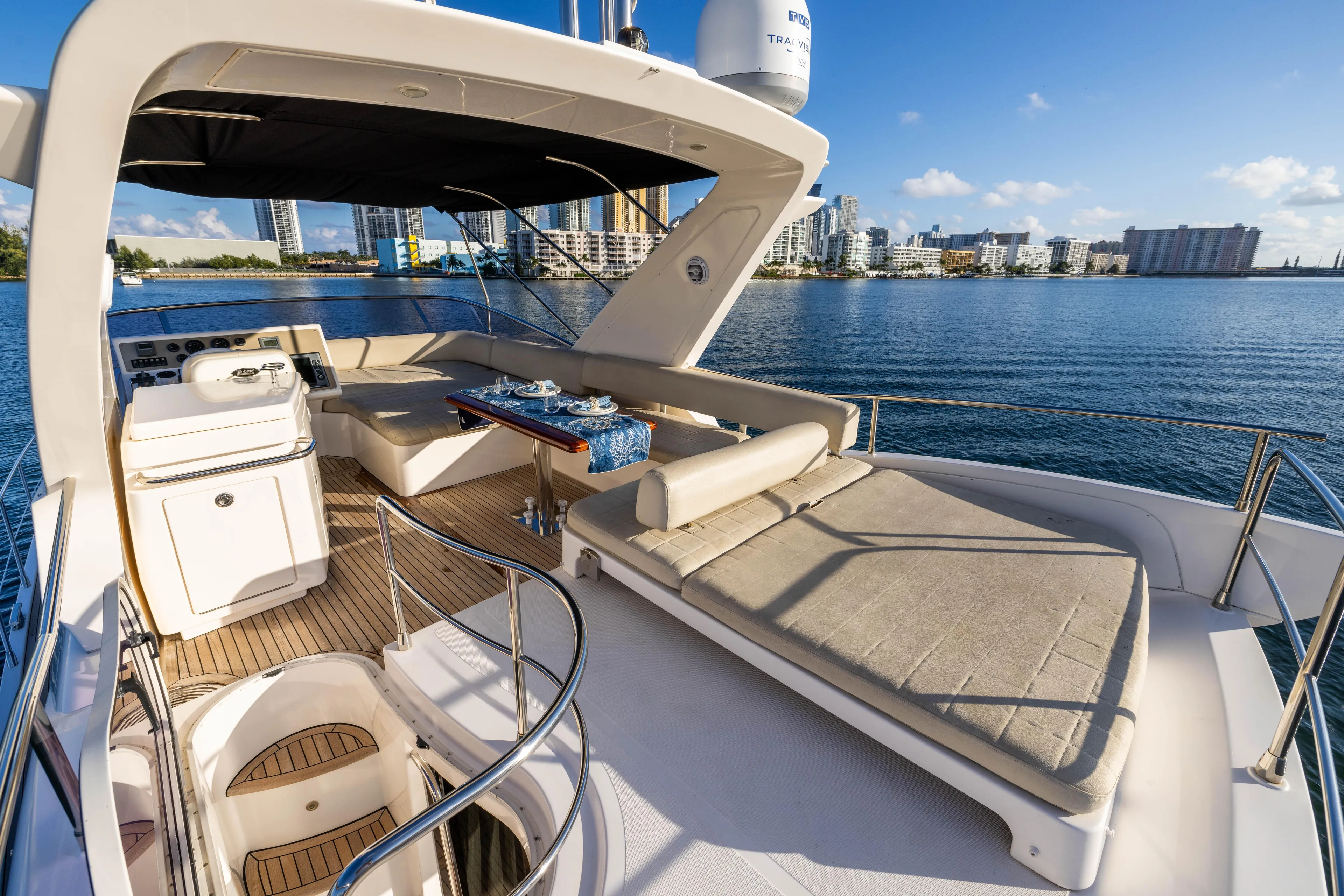 Blue Sea Yacht Photos Pics Luxurious 2012 Azimut 53 yacht deck with seating, overlooking serene waterfront cityscape.