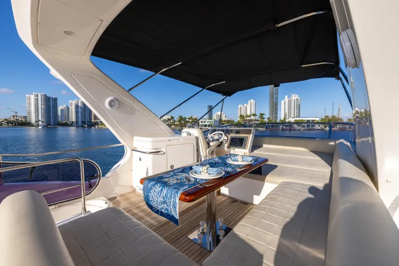 Blue Sea Yacht Photos Pics Luxurious 2012 Azimut 53 yacht deck with elegant dining setup and waterfront city view.