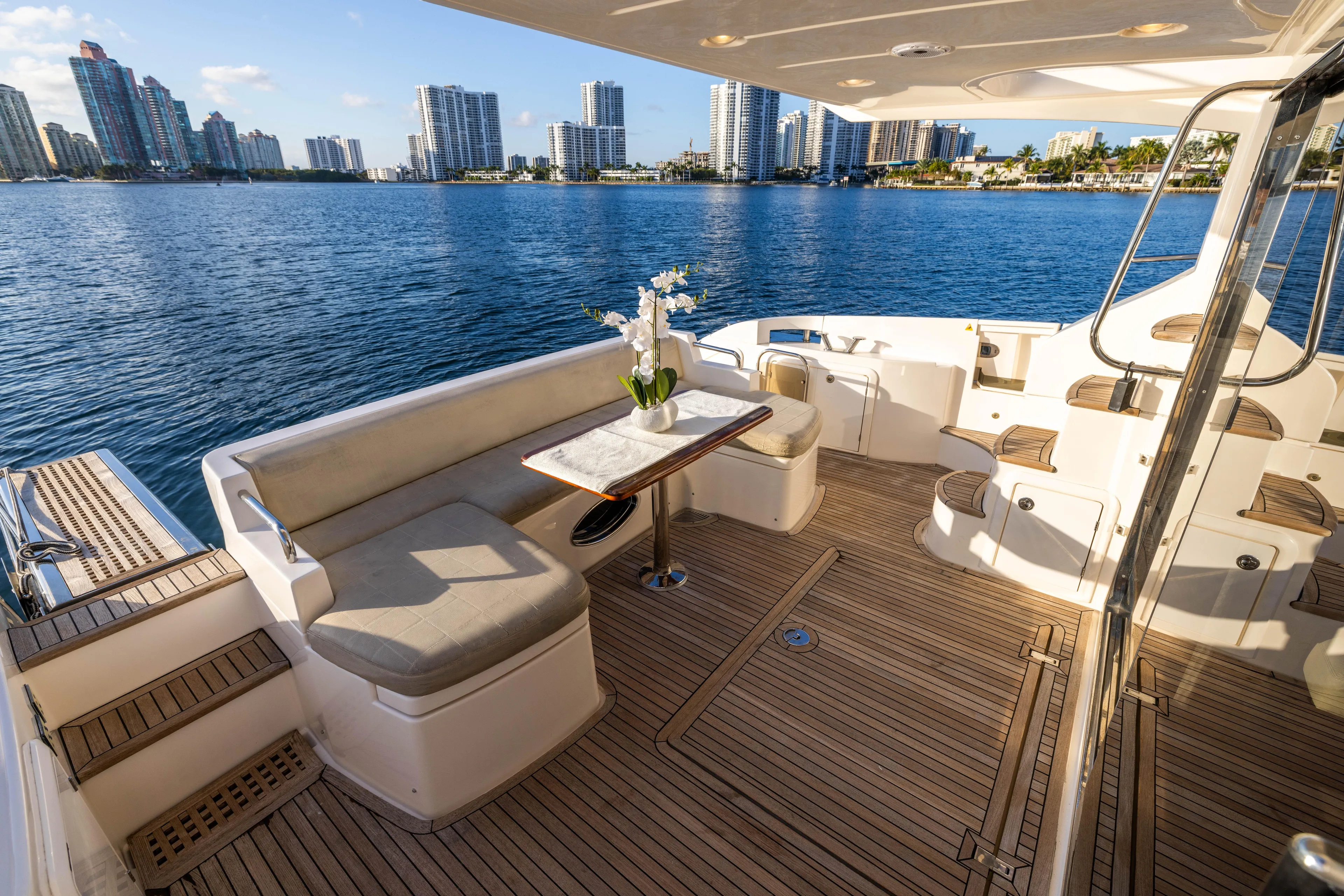 Blue Sea Yacht Photos Pics Luxurious 2012 Azimut 53 yacht deck with seating, table, and waterfront city view.