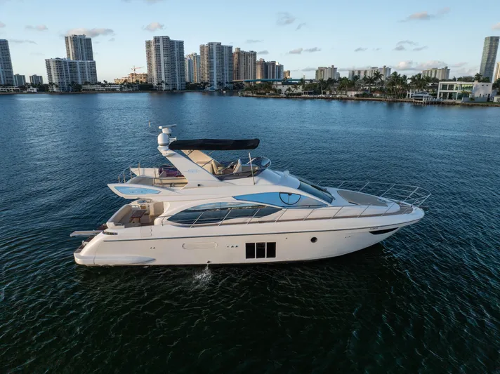 Blue Sea Yacht Photos Pics Luxury 2012 Azimut 53 yacht cruising near city skyline on calm waters.