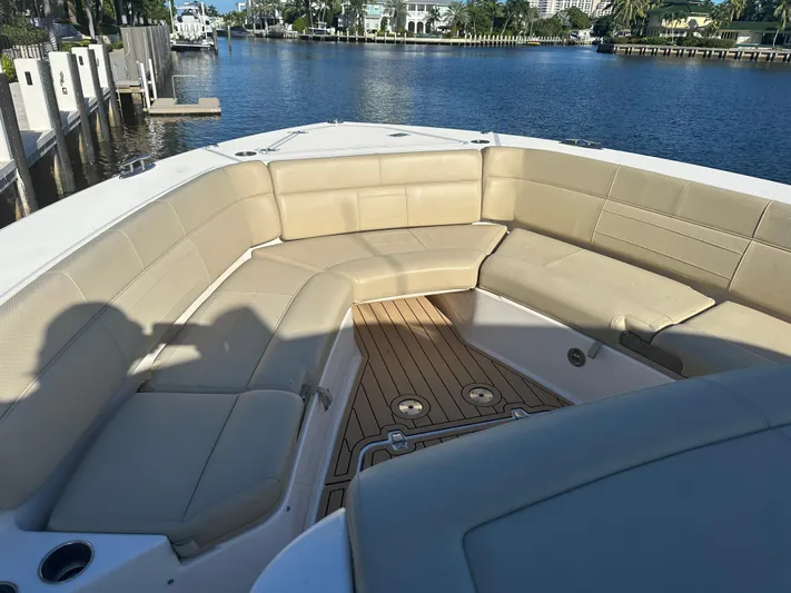 Leap Year Yacht Photos Pics 2018 Pursuit 408S boat with spacious seating, docked by a scenic waterfront.