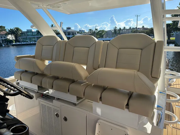 Leap Year Yacht Photos Pics Luxurious seating on a 2018 Pursuit 408S boat, overlooking a scenic waterfront.