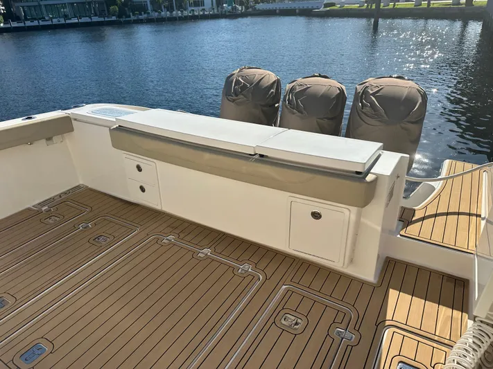 Leap Year Yacht Photos Pics 2018 Pursuit 408S boat deck with covered engines, docked by the water.