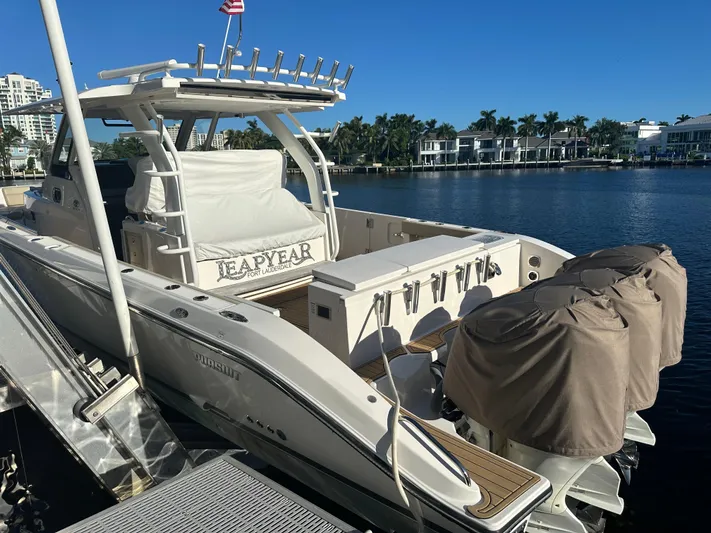 Leap Year Yacht Photos Pics 2018 Pursuit 408S boat docked by waterfront homes under clear blue sky.
