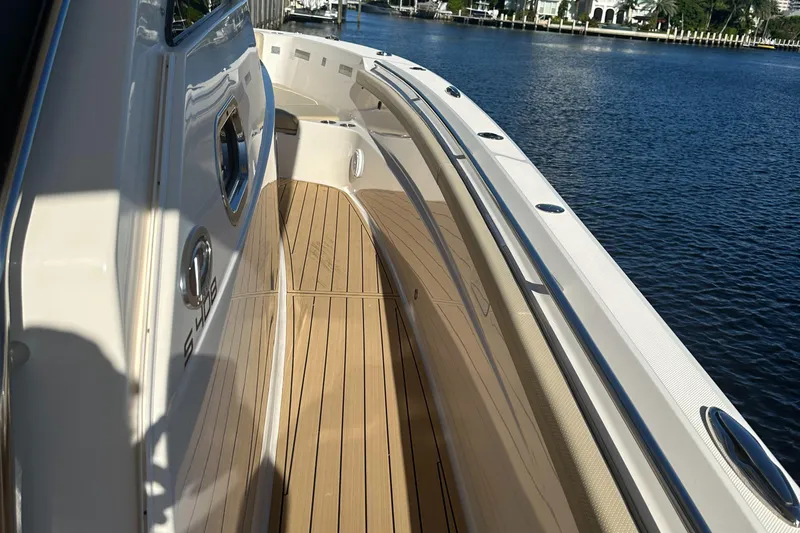 Leap Year Yacht Photos Pics 2018 Pursuit 408S boat deck with wood finish, docked by calm waters.