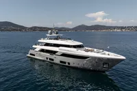 Luxurious 2022 Custom Line 37 yacht cruising on serene waters with scenic mountain backdrop.