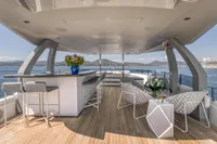 Luxurious yacht deck with modern seating, bar area, and ocean view, Custom Line 37, 2022 model.