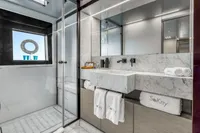Luxurious yacht bathroom with marble sink, glass shower, and elegant decor, Custom Line 37, 2022.