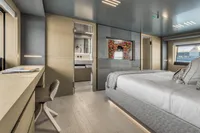 Luxurious yacht bedroom interior with modern decor, desk, and ensuite bathroom, Custom Line 37, 2022.