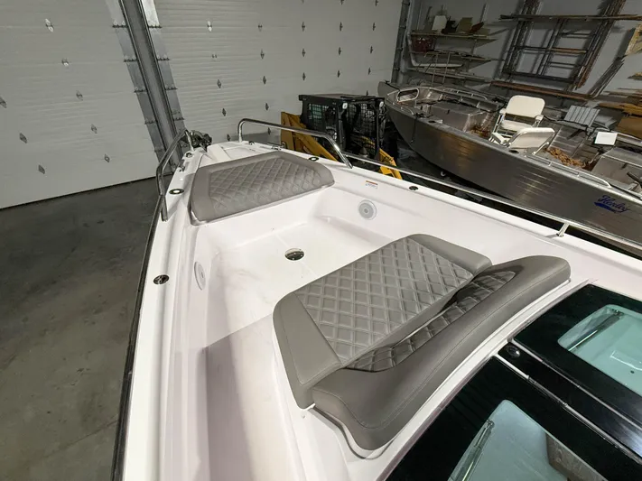  Yacht Photos Pics 2021 Axopar 37 XC CROSS CABIN boat with cushioned seating in a garage setting.