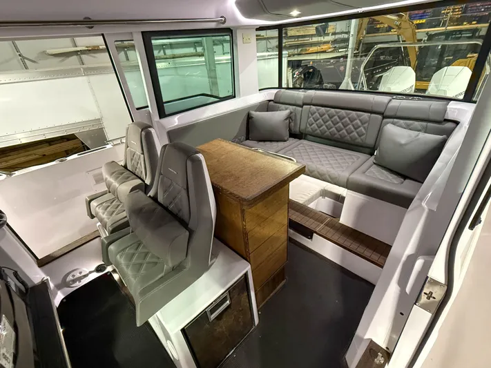  Yacht Photos Pics Interior of 2021 Axopar 37 XC CROSS CABIN with seating and table, showcasing modern design.