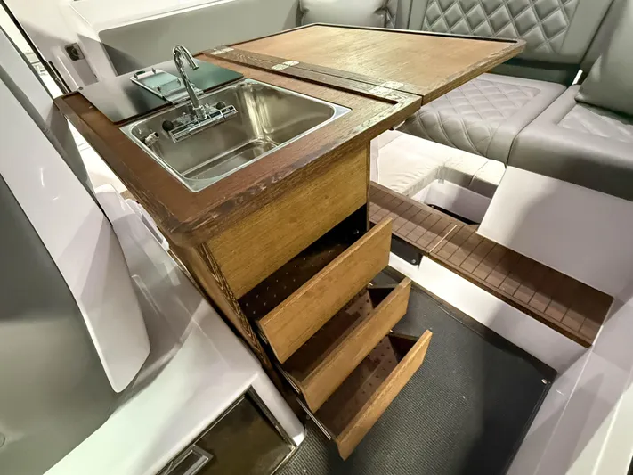  Yacht Photos Pics 2021 Axopar 37 XC CROSS CABIN interior with wooden kitchenette, sink, and seating area.