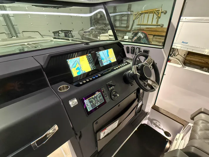 Yacht Photos Pics 2021 Axopar 37 XC CROSS CABIN dashboard with navigation screens and steering wheel.