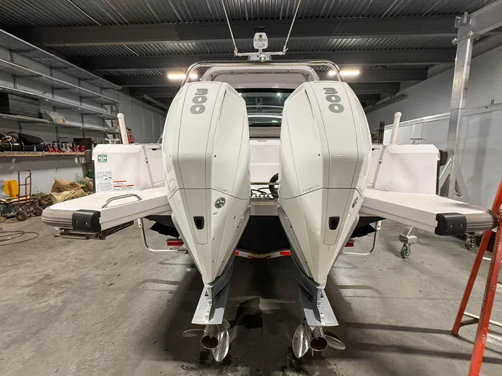  Yacht Photos Pics 2021 Axopar 37 XC CROSS CABIN with dual outboard engines in a garage setting.